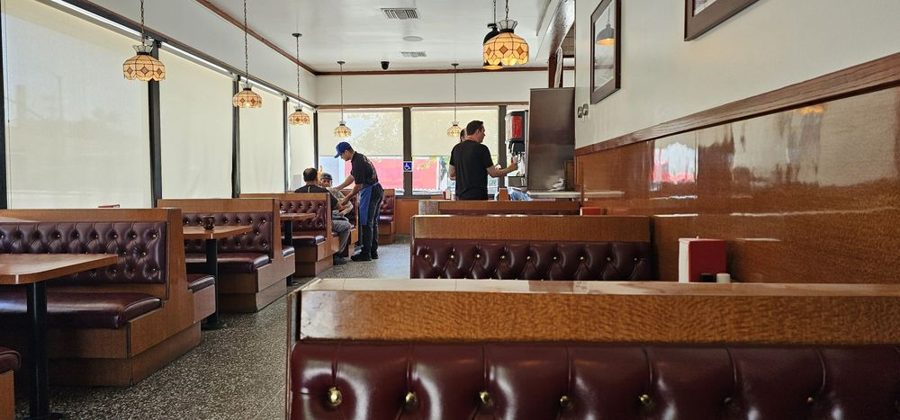 Rows of oxblood tufted leather booths under stained-glass pendant lamps inside Pete's Blue Chip
